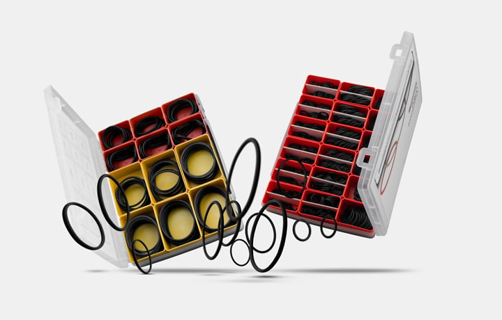 Selection of organizer cases with compartments containing assortments of black O-rings in various sizes on a light background